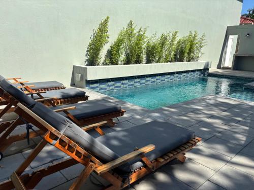 a group of lounge chairs next to a swimming pool at Beach Wood Boutique Hotel & Resort in Ballito