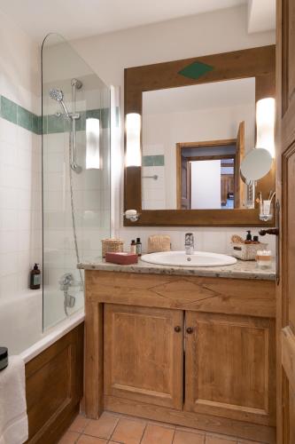 a bathroom with a sink and a shower and a mirror at Résidence Pierre & Vacances Premium Arc 1950 Le Village in Arc 1950