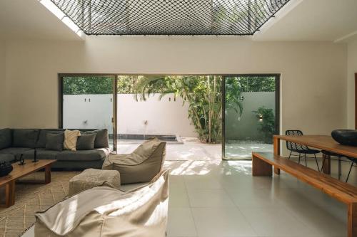 a living room with a couch and a table at Large 6BR Tulum Villa with Pool Aldea Zama in Tulum