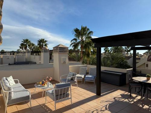 a patio with chairs and tables on a roof at Roda Golf Sunparadise in San Javier