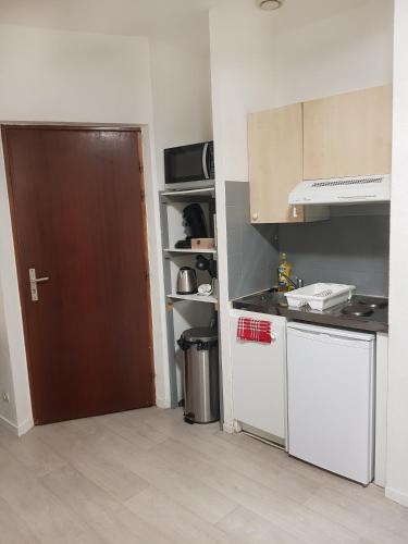 une cuisine avec une porte marron et un comptoir dans l'établissement Spacieux studio – Place de la république, à Dijon