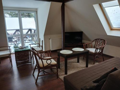 a living room with a bed and a table and chairs at Pensjonat Magdalena in Szklarska Poręba