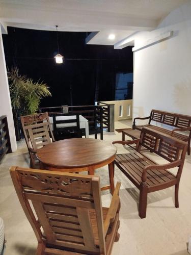 a wooden table and chairs and a table and chairs at Siyon Yula - Guest House in Hikkaduwa