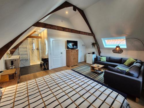 an attic room with a bed and a living room at B&B van Zon aan Zee in Vlissingen