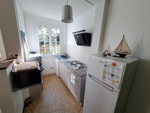 Il comprend une cuisine équipée d'un réfrigérateur blanc et d'une cuisinière. dans l'établissement Villa Saint Trojan, à Saint-Trojan-les-Bains