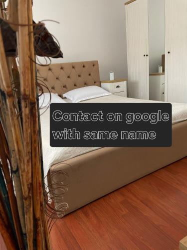 a bed in a room with words contact on google with same name at Iosia Premium Apartment in Oradea