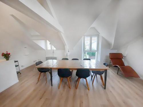- une table et des chaises en bois dans une grande pièce dans l'établissement Legrand - 90m2, 6 Prs, 3 Ch, Proche Gare, à Dijon