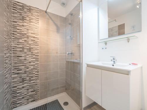 une salle de bain blanche avec une douche et un lavabo dans l'établissement La DUNE N 01 - VILLA 3P6, à Valras-Plage