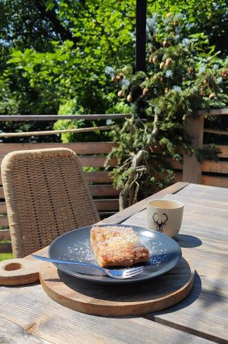 a blue plate with a piece of bread and a cup of coffee at Chata Fraluq in Tatobity