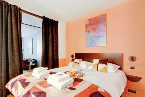 une chambre avec un lit avec des serviettes dessus dans l'établissement V Vast Apartment, Steps from Place des Vosges AC, à Paris