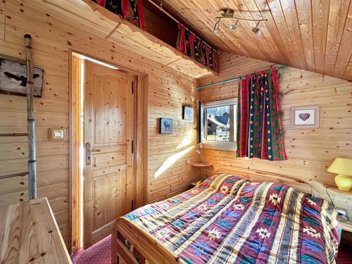 une chambre avec un lit dans une cabane en bois dans l'établissement ob219 4 pieces duplex 6 personnes proche pistes, aux Carroz d'Arâches