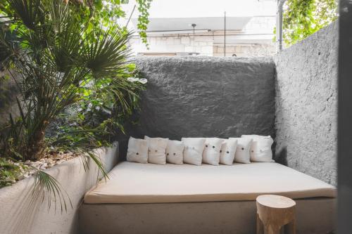 a bench sitting on a concrete wall with plants at GAIA Alaçatı Bazaar in Alacati