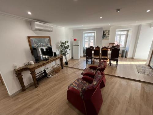 a living room with a couch and a table and chairs at Castle House Loulé City Center in Loulé