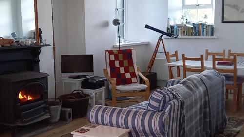 a living room with a couch and a fireplace at The Old Schoolhouse in New Quay
