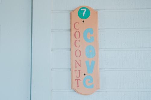 a welcome sign hanging on a white door at Guana Beach Inn in Great Guana Cay