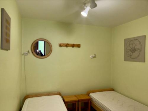 a room with two beds and a mirror at Charmant 2 pièces avec balcon exposé Sud, proche télésiège et commerces, Vieil Alpe - FR-1-405-216 in LʼHuez