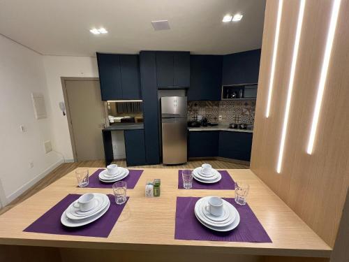 a kitchen with blue cabinets and a table with white dishes at LK Santo Agostinho 6 in Belo Horizonte