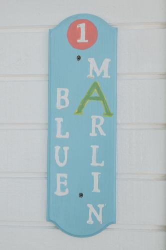 a blue sign on the side of a house at Guana Beach Inn in Great Guana Cay