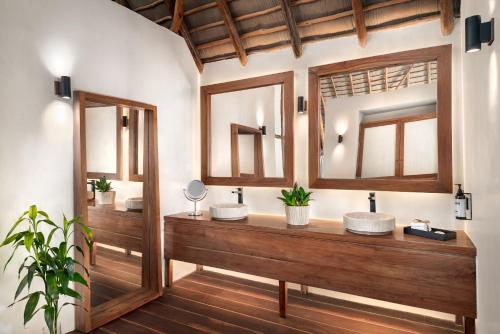 a bathroom with two sinks and two mirrors at Secrets Tulum Resort & Beach Club - Adults Only - All Inclusive in Tulum