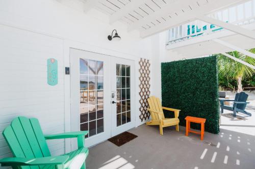 a porch with colorful chairs on a patio at Guana Beach Inn in Great Guana Cay