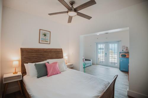 a bedroom with a bed with a ceiling fan at Guana Beach Inn in Great Guana Cay