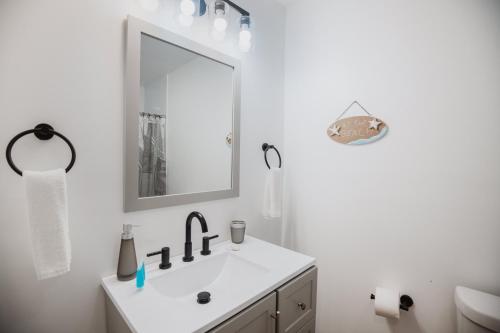 a white bathroom with a sink and a mirror at Guana Beach Inn in Great Guana Cay