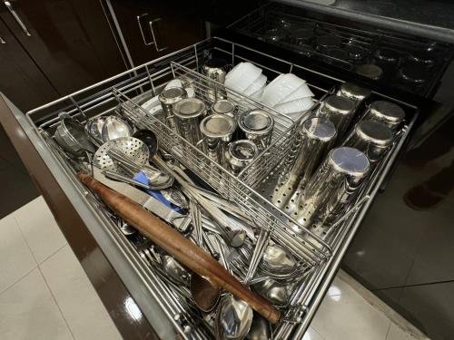 a dish rack filled with utensils in a kitchen at OSI Apartments Kurla West in Mumbai