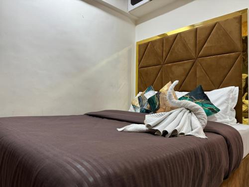 a bedroom with a large bed with a large headboard at OSI Apartments Kurla West in Mumbai
