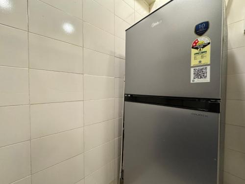 a metal refrigerator in a room with a wall at OSI Apartments Kurla West in Mumbai
