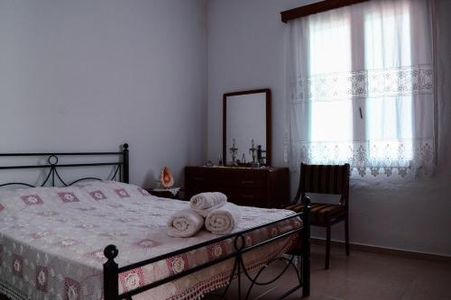 a bedroom with a bed and a dresser and a mirror at Tsikalario Holiday House in Tsikkalarión
