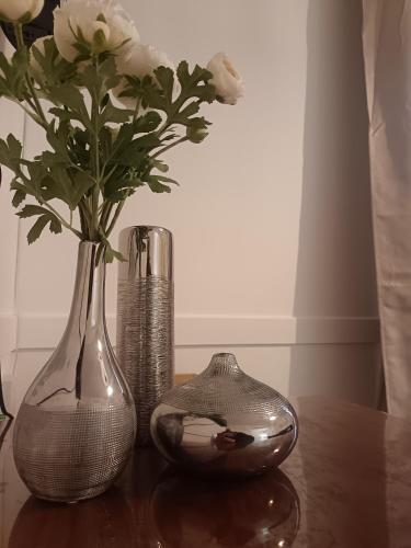 three vases sitting on a wooden table with flowers at Charmant Studio in Marseille