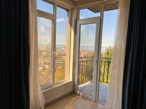 a room with large windows with a view of a city at GT House Batumi in Batumi