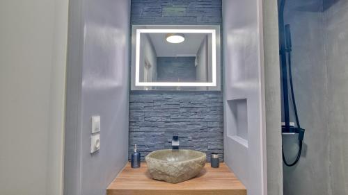 La salle de bains est pourvue d'un lavabo et d'un bol en pierre. dans l'établissement Le Grain de Sable, au Cap d'Agde