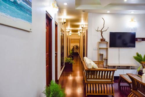 a living room with chairs and a tv on a wall at Laguna Retreat in Vaadhoo