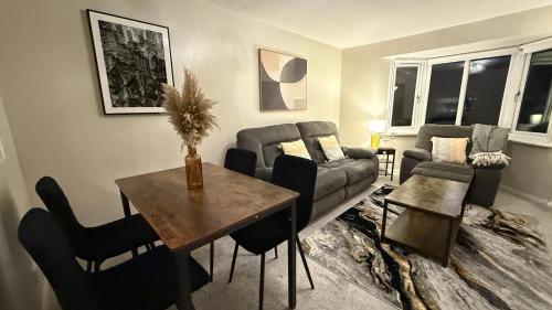 a living room with a couch and a table and chairs at 2 Bedroom Ap Close to Woking town with Free Parking in Horsell