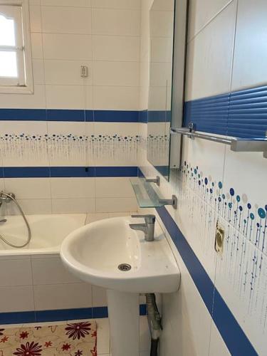 a white bathroom with a sink and a tub at Dar Sammoud A1 in Kelibia