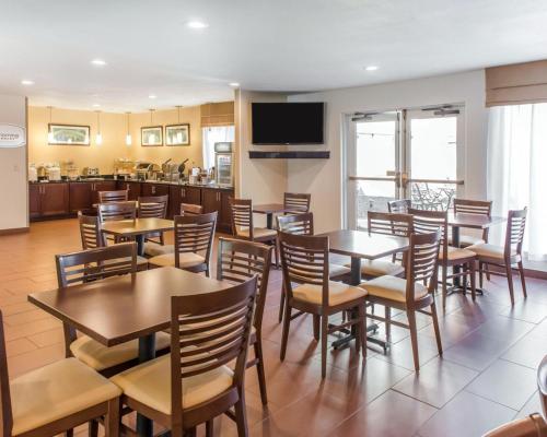 a restaurant with tables and chairs and a kitchen at MainStay Suites Pittsburgh Airport in Imperial
