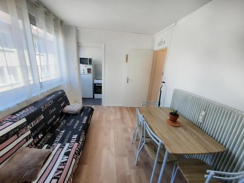 - un salon avec une table et un banc avec des livres dans l'établissement Courtépée - Apt 2 Prs avec balcon en centre ville, à Dijon