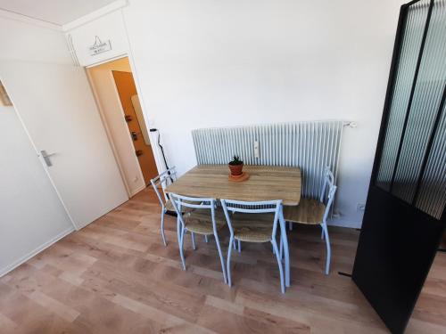 une salle à manger avec une table et des chaises en bois dans l'établissement Courtépée - Apt 2 Prs avec balcon en centre ville, à Dijon