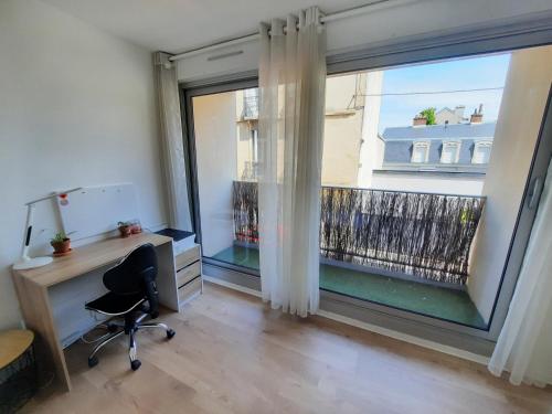 un bureau avec un bureau et une grande fenêtre dans l'établissement Courtépée - Apt 2 Prs avec balcon en centre ville, à Dijon
