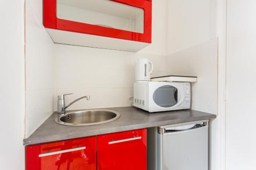 une petite cuisine avec un évier et un micro-ondes dans l'établissement Cozy studio - 2P - Next to Paris, à Malakoff