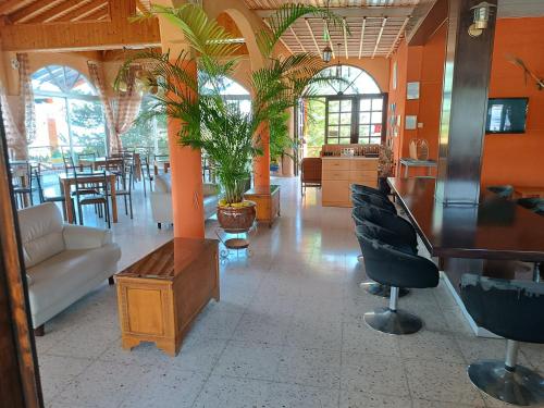 a large room with tables and chairs and plants at Rantzo Holiday Apartments in Pissouri