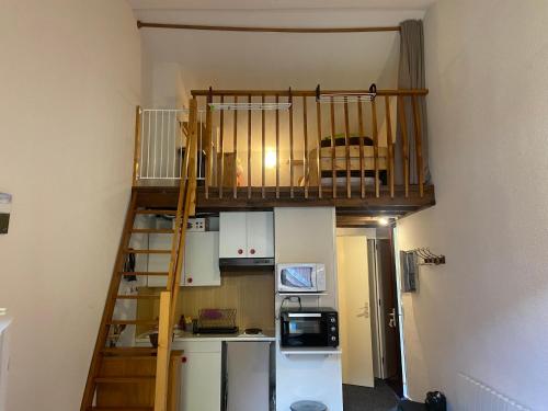une petite cuisine avec un escalier menant à une mezzanine dans l'établissement Appartement chalet, à Montferrier