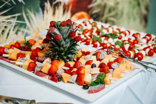 a tray filled with fruit and cheese on a table at Best Western Hotel München Airport in Erding