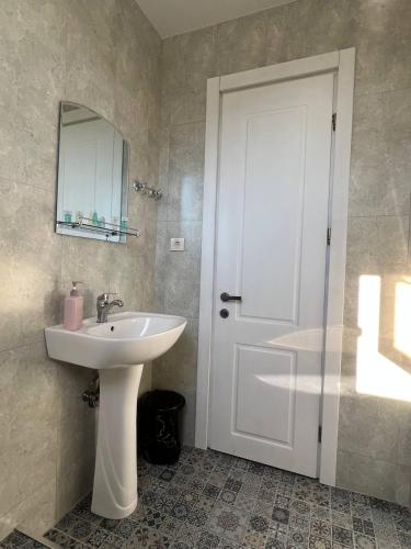 a bathroom with a white sink and a mirror at GT House Batumi in Batumi
