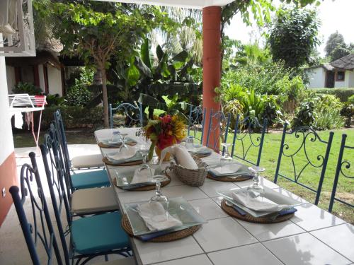 a table with chairs and plates and flowers on it at Teranga saly senegal in Saly Portudal