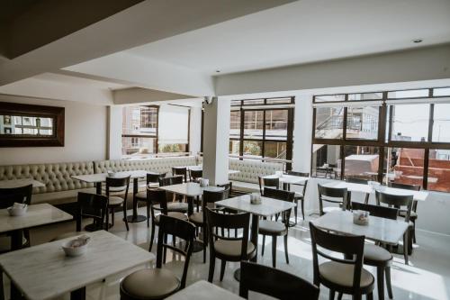 a restaurant with tables and chairs and windows at Hotel Club del Golf in Mar del Plata