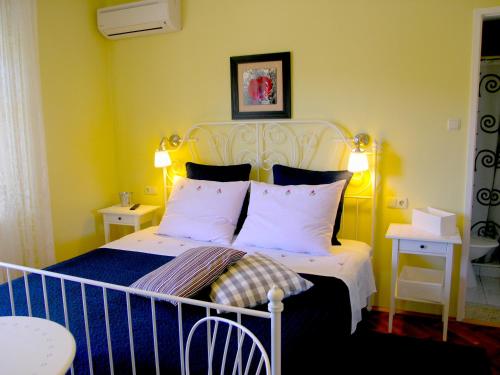 a bedroom with a white bed with two pillows at House Rozi in Rab