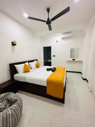 a bedroom with a large bed with a ceiling fan at Kyali Homestay Tangalle in Tangalle