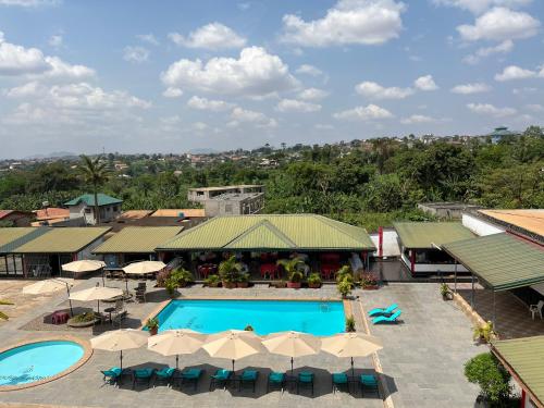 an aerial view of a resort with a pool and umbrellas at Prodiges Hôtel in Yaoundé